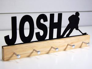 Our personalized hockey medal holder is a unique gift for the hockey player in your life. This display will be the perfect way for them to show off all of their well-deserved awards. This design comes in a variety of colors, or you can pick from our other choices of sports or phrases so we can customize it just the way you want!