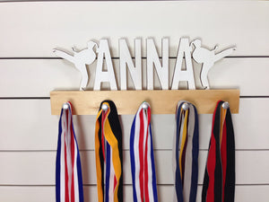  Our personalized martial arts medal holder is a unique gift for the fighter in your life. This display will be the perfect way for them to show off all of their well-deserved awards. This design comes in a variety of colors, or you can pick from our other choices of sports or phrases so we can customize it just the way you want!