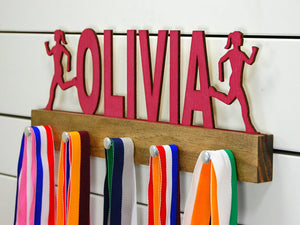 Our personalized running medal holder is a great gift for your runner girl so she can display all of her awesome awards. This design comes in a variety of colors, or you can pick from our other choices of sports or phrases so we can customize it just the way you want!