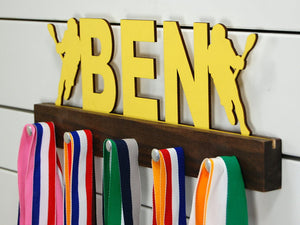 Our personalized lacrosse medal holder is a unique gift for the lacrosse player in your life. This display will be the perfect way for him to show off all of his well-deserved awards. This design comes in a variety of colors, or you can pick from our other choices of sports or phrases so we can customize it just the way you want!
