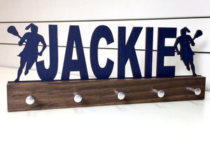 Our personalized lacrosse medal holder is a unique gift for the lacrosse player in your life. This display will be the perfect way for her to show off all of her well-deserved awards. This design comes in a variety of colors, or you can pick from our other choices of sports or phrases so we can customize it just the way you want!
