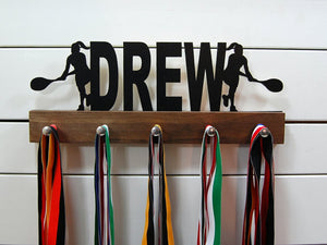 Our personalized tennis medal holder is a unique gift for the tennis player in your life. This display will be the perfect way for her to show off all of her well-deserved awards. This design comes in a variety of colors, or you can pick from our other choices of sports or phrases so we can customize it just the way you want!
