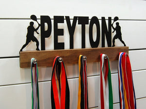  Our personalized tennis medal holder is a unique gift for the tennis player in your life. This display will be the perfect way for him to show off all of his well-deserved awards. This design comes in a variety of colors, or you can pick from our other choices of sports or phrases so we can customize it just the way you want!