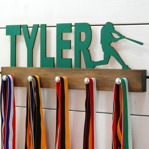  Our personalized baseball medal holder is a unique gift for the ballplayer in your life. This display will be the perfect way for him to show off all of his awards. This design comes in a variety of colors, or you can pick from our other choices of sports or phrases so we can customize it just the way you want!