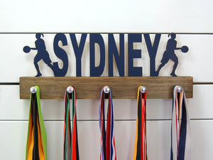  Our personalized basketball medal holder is a unique gift for the b-baller in your life. This display will be the perfect way for her to show off all of her awards. This design comes in a variety of colors, or you can pick from our other choices of sports or phrases so we can customize it just the way you want!