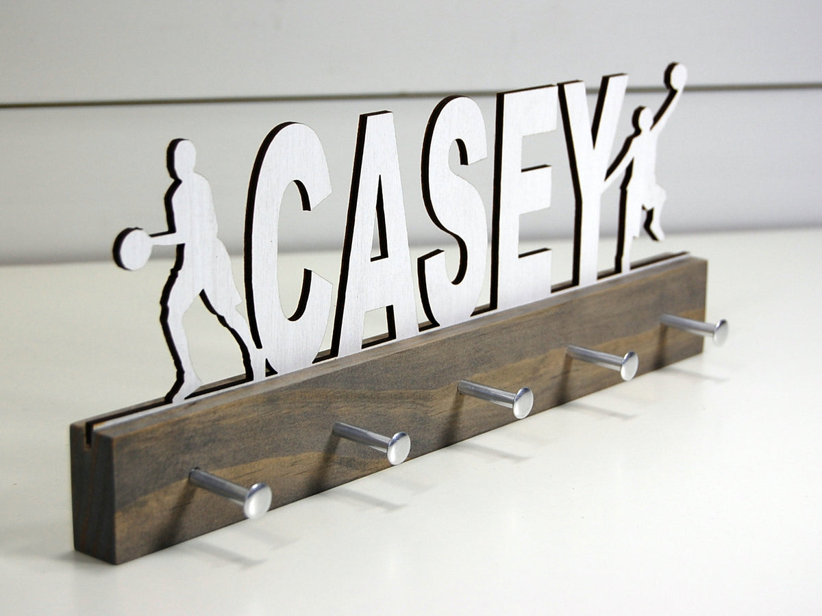  Our personalized basketball medal holder is a unique gift for the b-baller in your life. This display will be the perfect way for him to show off all of his awards. This design comes in a variety of colors, or you can pick from our other choices of sports or phrases so we can customize it just the way you want!