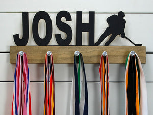  Our personalized hockey medal holder is a unique gift for the hockey player in your life. This display will be the perfect way for them to show off all of their well-deserved awards. This design comes in a variety of colors, or you can pick from our other choices of sports or phrases so we can customize it just the way you want!