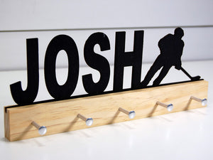  Our personalized hockey medal holder is a unique gift for the hockey player in your life. This display will be the perfect way for them to show off all of their well-deserved awards. This design comes in a variety of colors, or you can pick from our other choices of sports or phrases so we can customize it just the way you want!