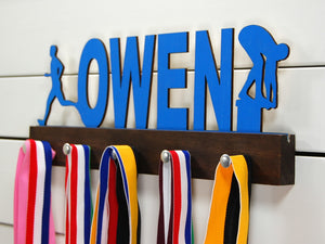 Our personalized multi-sport medal holder is a unique gift for the talented athlete in your life. This display will be the perfect way for them to show off all of their well-deserved awards. This design comes in a variety of colors, or you can pick from our other choices of sports or phrases so we can customize it just the way you want!