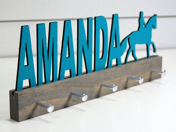  Our personalized equestrian medal holder is a unique gift for the horse-lover in your life. This display will be the perfect way for them to show off all of their well-deserved awards. This design comes in a variety of colors, or you can pick from our other choices of sports or phrases so we can customize it just the way you want!