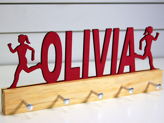  Our personalized running medal holder is a great gift for your runner girl so she can display all of her awesome awards. This design comes in a variety of colors, or you can pick from our other choices of sports or phrases so we can customize it just the way you want!