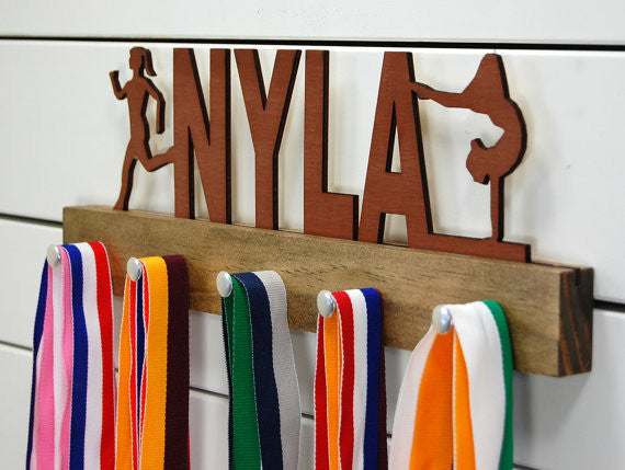 Our personalized multi-sport medal holder is a unique gift for the talented athlete in your life. This display will be the perfect way for them to show off all of their well-deserved awards. This design comes in a variety of colors, or you can pick from our other choices of sports or phrases so we can customize it just the way you want!