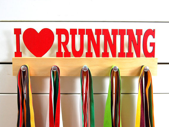 Our running medal holder is the perfect gift for anyone who loves running as much as we do! This display will help them show off all of their well-deserved awards. This design comes in a variety of colors, or you can pick from our other choices of sports or phrases. Better yet, tell us your own personal mantra so we can customize a unique medal holder just for you!